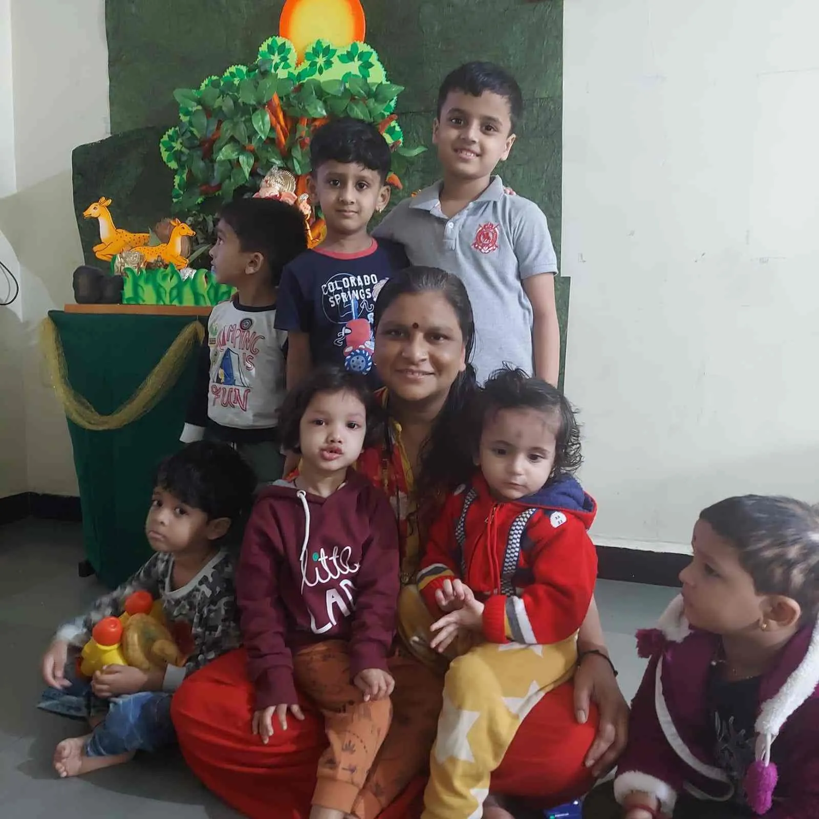 Kaku with children in front of the Ganpati festival decoration at Maza Ghar